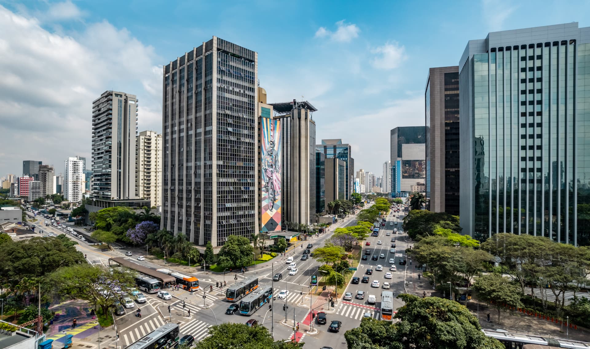 Aerial view of a São Paulo avenue lined with skyscrapers, trees and traffic